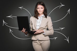 A business woman holding a laptop computer, representing increasing female workforce participation in Brazil.